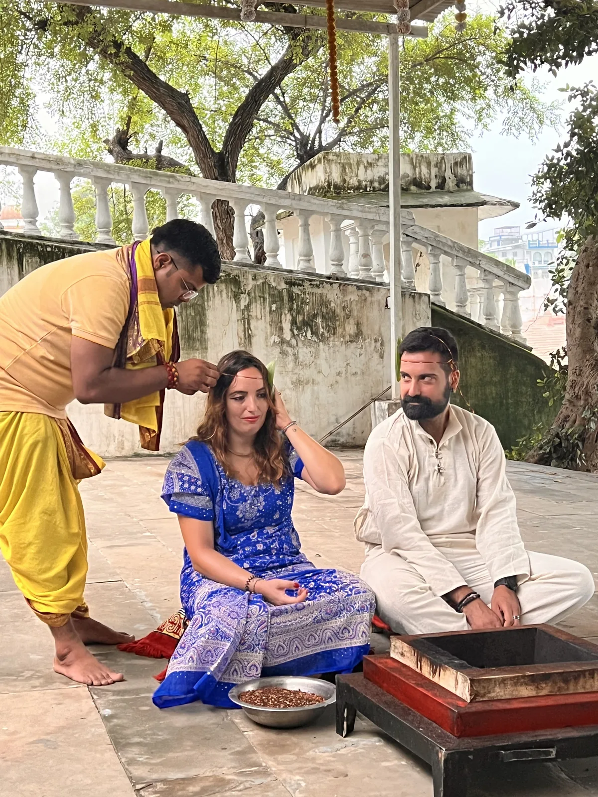 A priest guides a couple through a Hindu wedding ritual