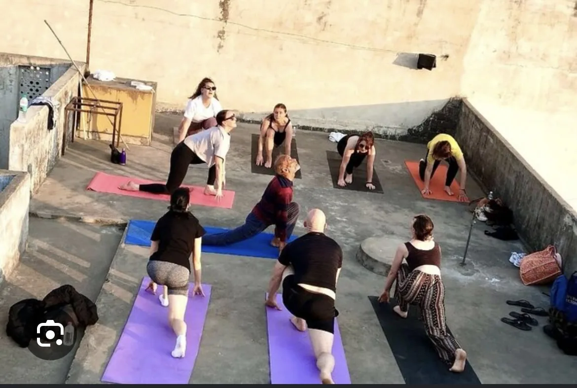 A small group practices yoga together on a rooftop in Pushkar