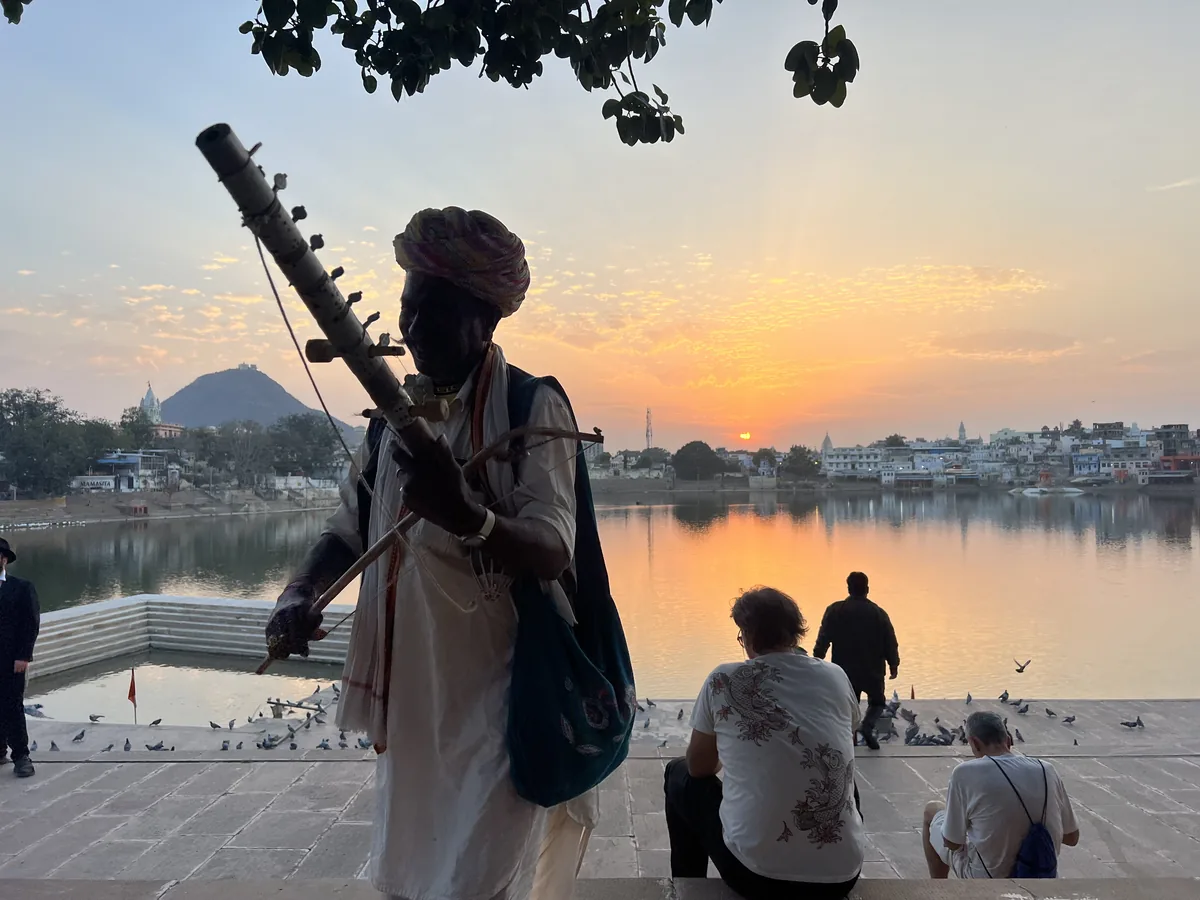 A traveller watches the sunset over Pushkar Lake
