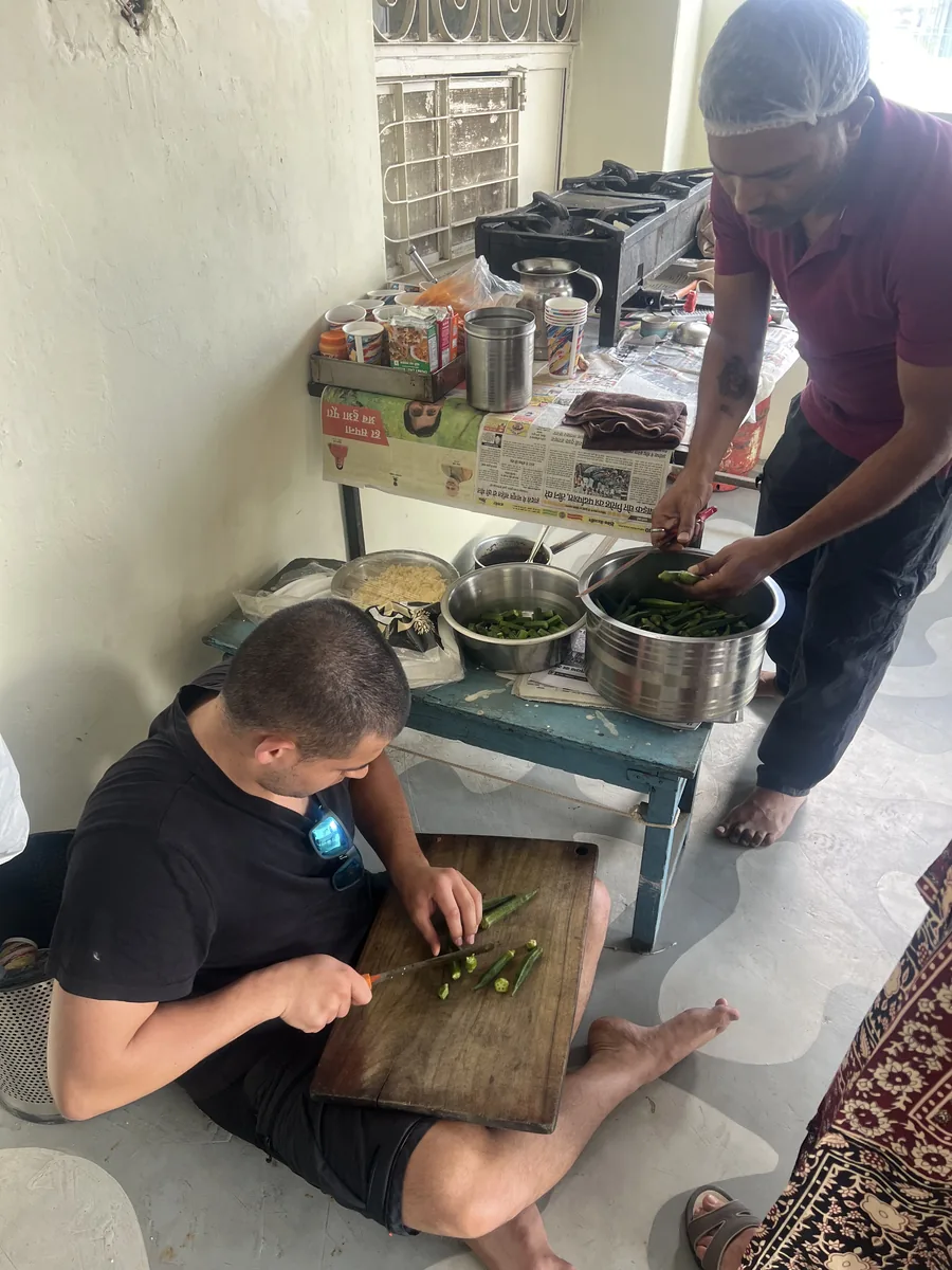 A guest learns a cooking technique in Pushkar