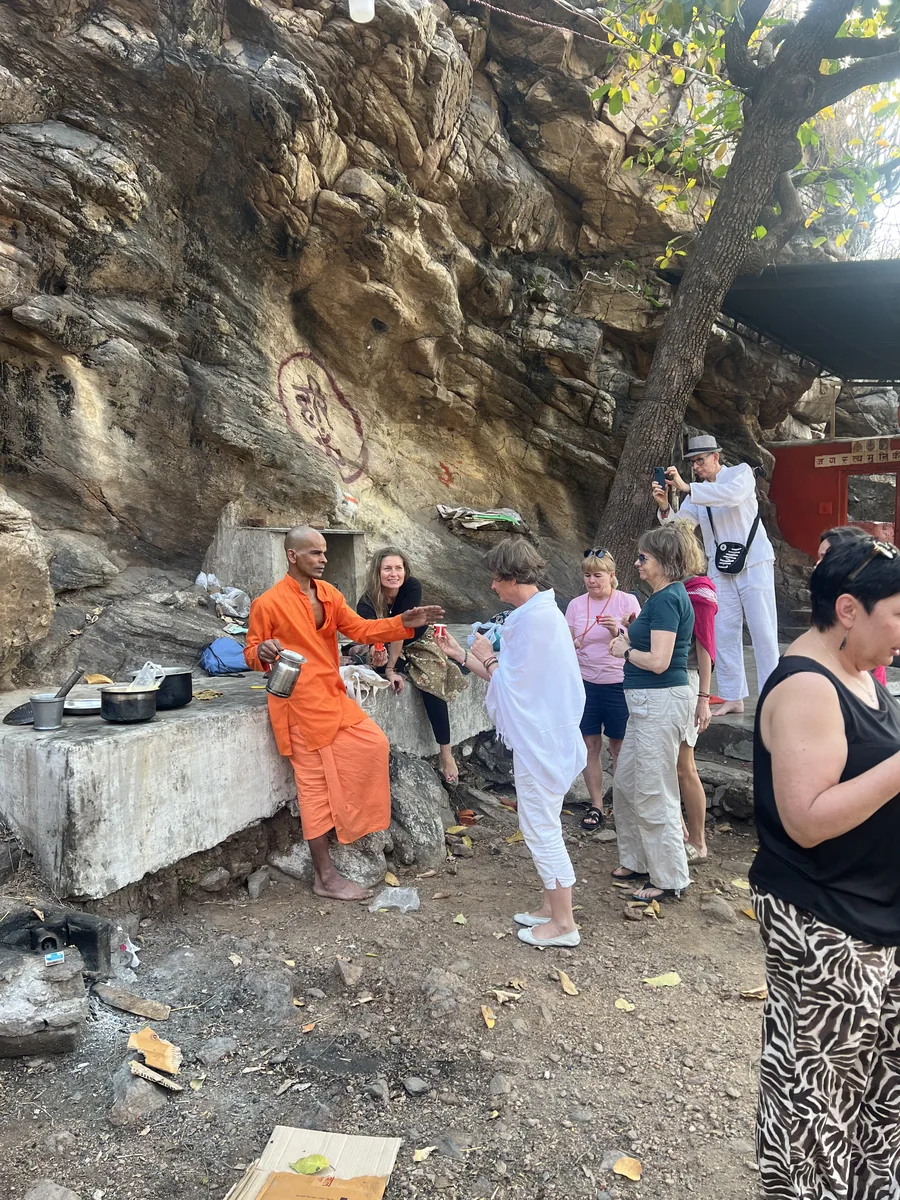 Visitors explore a natural cave in the hills around Pushkar